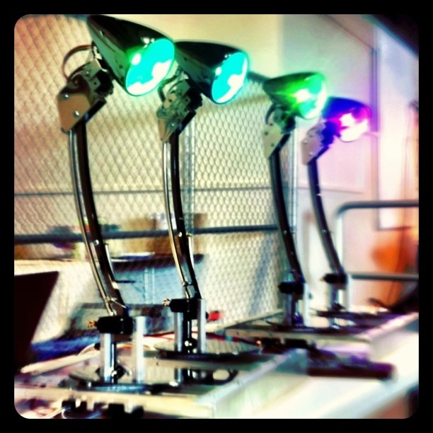 picture of four desk lamps in different poses with colorful light